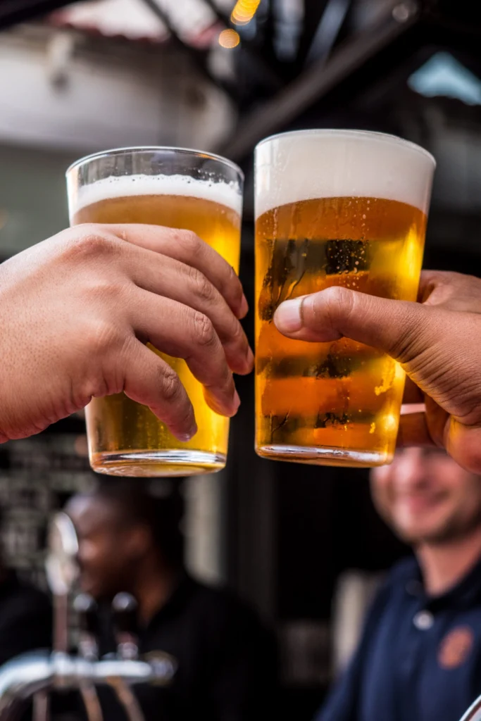 Deux verres de bière blonde qui trinquent